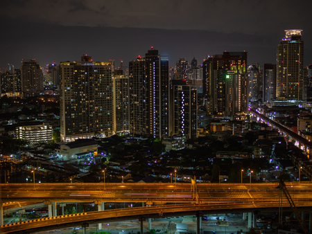 Buildings and highway road in city at nightの写真素材