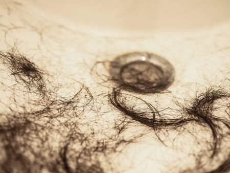 Close up of black hair on the sink - after cutting hair
