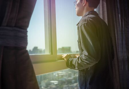 Man putting hands on windows, alone look out the roomの写真素材