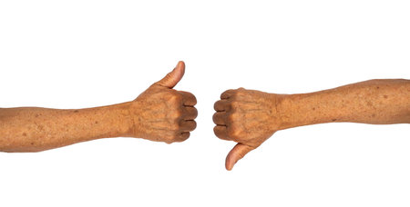 Thumb up and down senior hand gesture isolated on white backgroundの写真素材