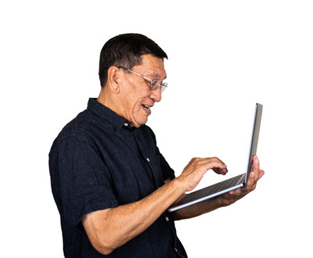Senior man using computer laptop happily isolated on white backgroundの写真素材