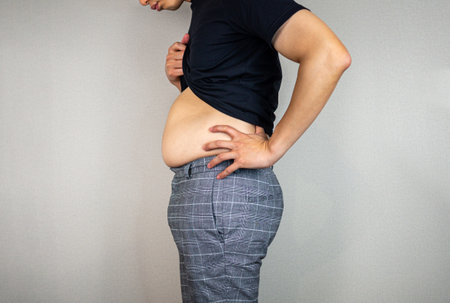 Big Tummy and looking worried by standing asian manの写真素材