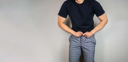 Wearing tight pants, Man trying to hook the pants as gaining weightの写真素材