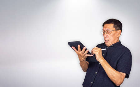 Senior man shocking at the tablet screenの写真素材