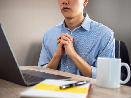 Pray in front of the laptopの写真素材