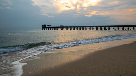 Old stone bridge  into the sea and Sea waves is in the foreground.の写真素材