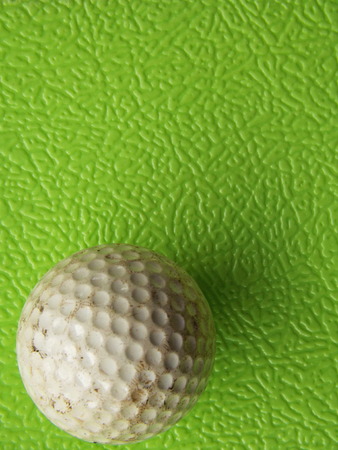 Golf ball past usage. On rough green backgroundの写真素材