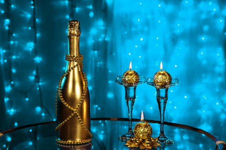A bottle of champagne and candles in New year and Christmas on blueの写真素材