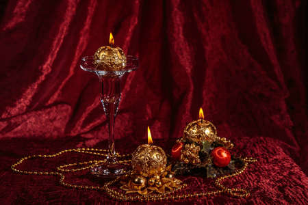 Christmas still life with spherical candles on Burgundyの写真素材