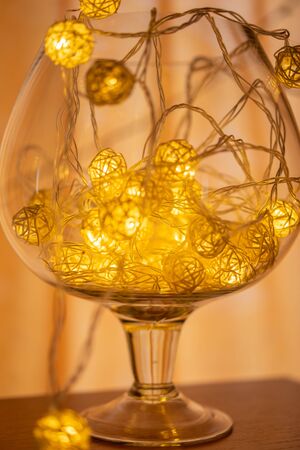 Glass vase with garland garland on orange backgroundの写真素材