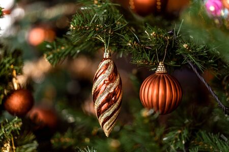 Christmas brown and gold candle hanging on pine branches with festive backgroundの写真素材