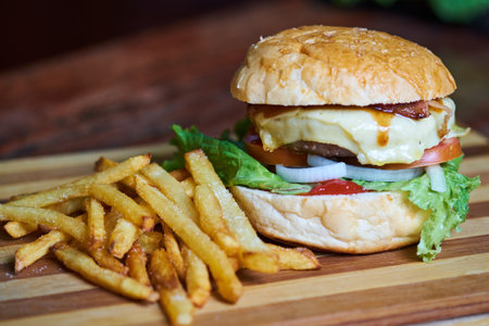 Cheese burger - American cheese burger with Golden French fries on wooden backgroundの写真素材