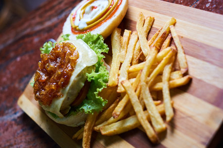 Cheese burger - American cheese burger with Golden French fries on wooden plate