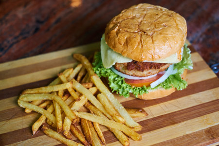 Cheese burger - American cheese burger with Golden French fries on wooden backgroundの写真素材