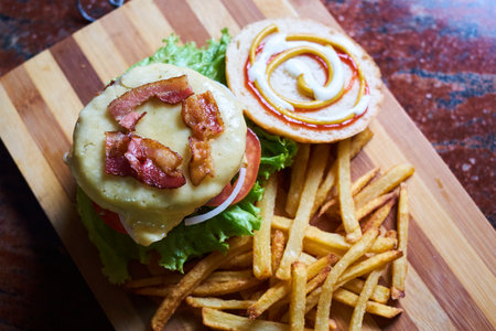 Cheese burger - American cheese burger with Golden French fries on wooden board