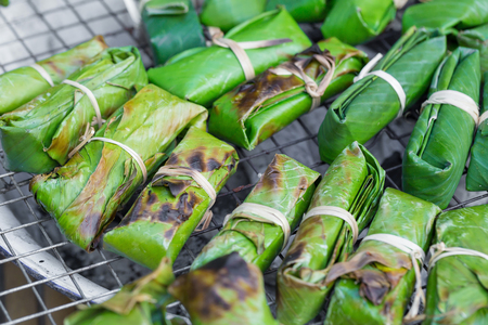 Thai Dessert, Freshly Homemade of Grilled Bananas in Sticky Rice Made From Banana or Taro and Glutinous Rice on Green Banana Leavesの写真素材