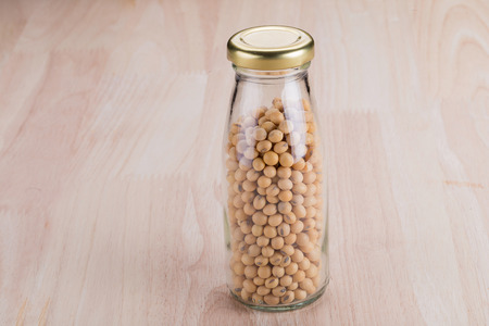 Close up Soybean in a glass bottle on wooden tableの写真素材