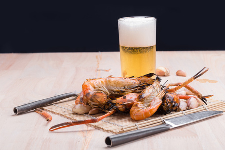 Burn shrim and Seafood sauce with beer on wooden tableの写真素材