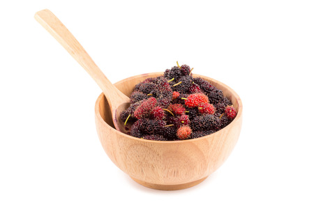 Mulberry berries in a wooden cup on a white background.の写真素材
