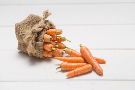 baby carrot vegetarian food on wooden table.の写真素材