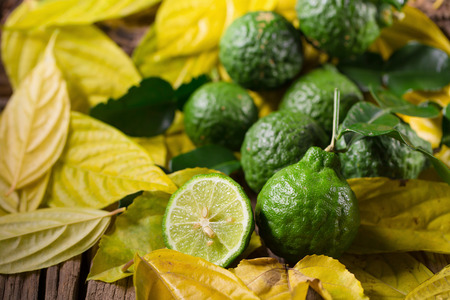 fresh bergamot and Yellow leaves on old wooden tables background.