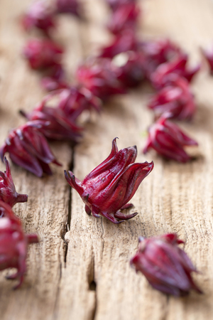 Roselle Hibiscus sabdariffa red fruit flower on wooden background. used for making tea or syrup.の写真素材