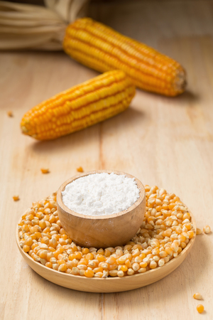 Corn flour in a bowl over a wooden table.の写真素材