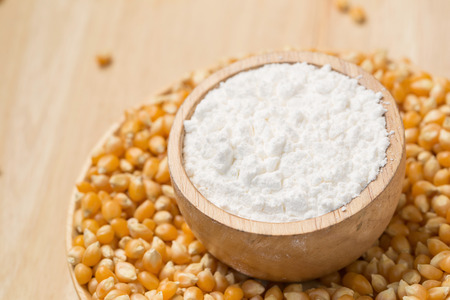 Corn flour in a bowl over a wooden table.