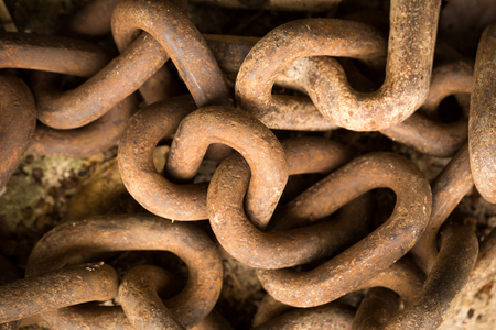 Big iron chains from an old ships anchor rusting by the harbor side close up.の写真素材