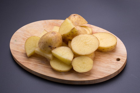Potatoes and potato sliced on a black background.の写真素材