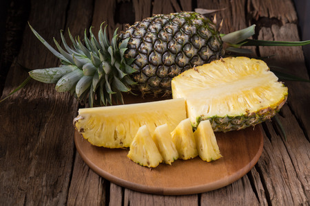 Ripe pineapple and pineapple slices on a wooden background tropical fruits.の写真素材