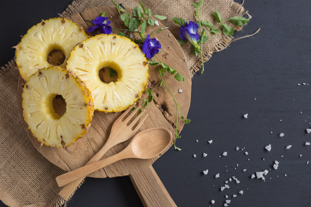 Fresh Yellow Organic Pineapple cut into slices on wooden table.の写真素材
