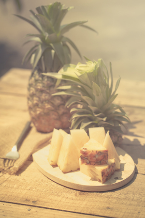 Pineapple slices and pineapple shelled Asian-style on the old wooden background. Tropical fruit concept.の写真素材