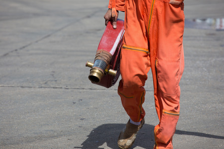 Rolled into a roll red fire hose, Fire equipment extinguishers ready to use in the outdoor.の写真素材