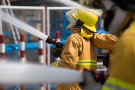 Firefighters spray water in fire extinguishers caused by explosive gas.の写真素材