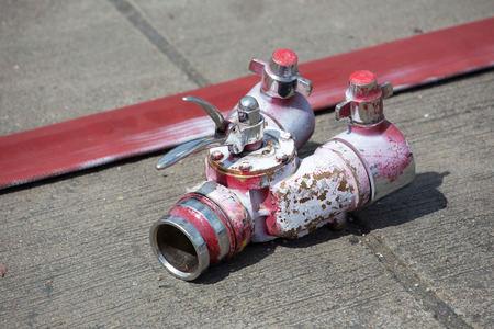 Rolled into a roll red fire hose, Fire equipment extinguishers ready to use in the outdoor.