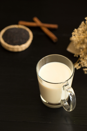 Glass of milk on black wooden background.の写真素材