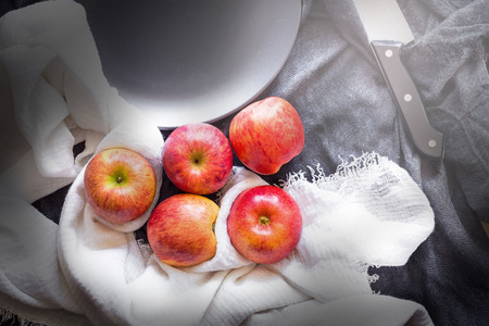 Red apples in a black bowl on a Black fabric background.の写真素材