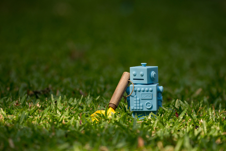 Blue Retro robot toys with garden tools in Natural green leaves background.の写真素材