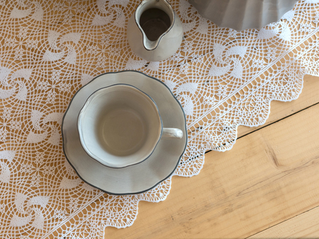 Tea set is Gray on a wooden background. Teapot, creamer, Cup and saucer on the table. Ceramic kitchenware.の写真素材