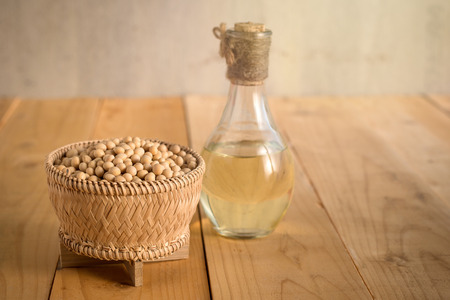 Soy bean and soy oil on a wooden table.の写真素材