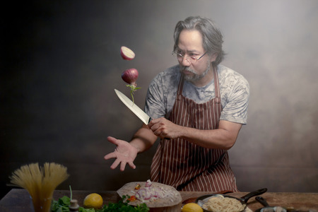 Man cook chef hipster with handsome bearded with a knife.の写真素材