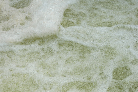 Powerful waves of water with white foam rising up.の写真素材