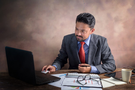 Handsome bearded businessman in formal wear and laptop.の写真素材