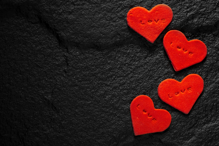 Red heart written love words placed on black stone floor.の写真素材