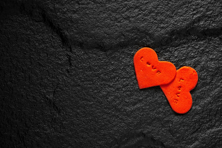Red heart written love words placed on black stone floor.の写真素材