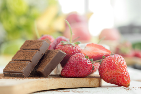 Chocolate, strawberry, blueberry and ice cubes on wooden plate.の写真素材