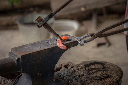 The blacksmith kicks a horseshoe close up.の写真素材