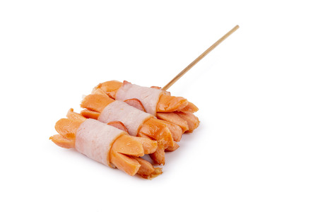 Small sausages wrapped in a blanket of smoked streaky bacon isolated on white background.の写真素材