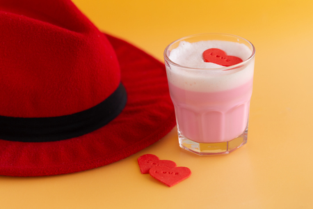 Red hat and Strawberry milk shake from the glass on yellow background.の写真素材